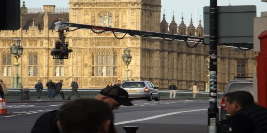 Residents of Westminster property pause to view the action on Westminster Bridge as film crews shoot for Transformers 5